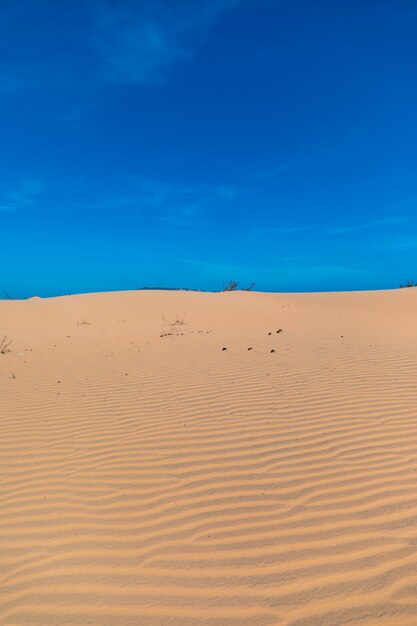 澄んだ青い空の下のムイネー、ビエンタムの美しい砂丘の垂直方向の画像
