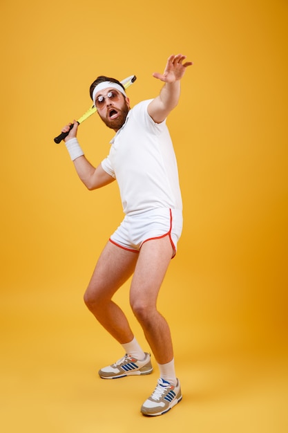 テニスで遊んで面白いスポーツマンの垂直方向の画像