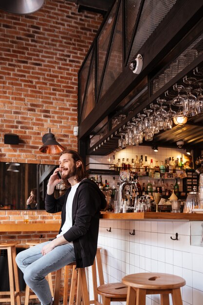バーに座っている男の垂直方向の画像