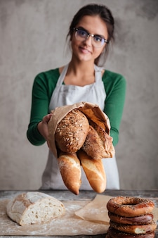 パン​と​女性​の​パン屋​表示​バッグ​の​垂直​方向​の​画像