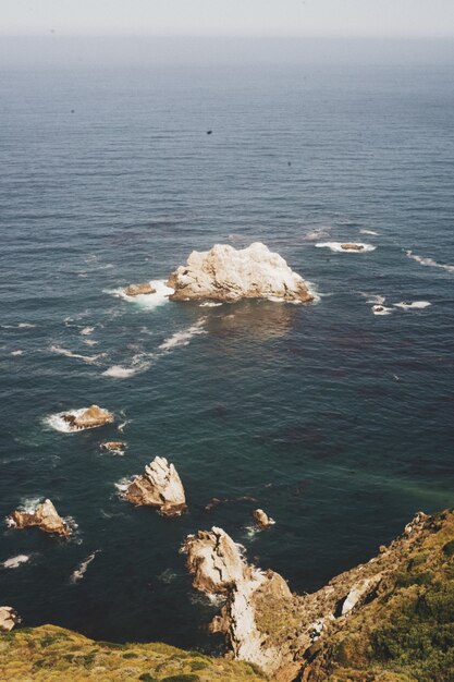 崖の海岸近くの海の岩の垂直方向の画像