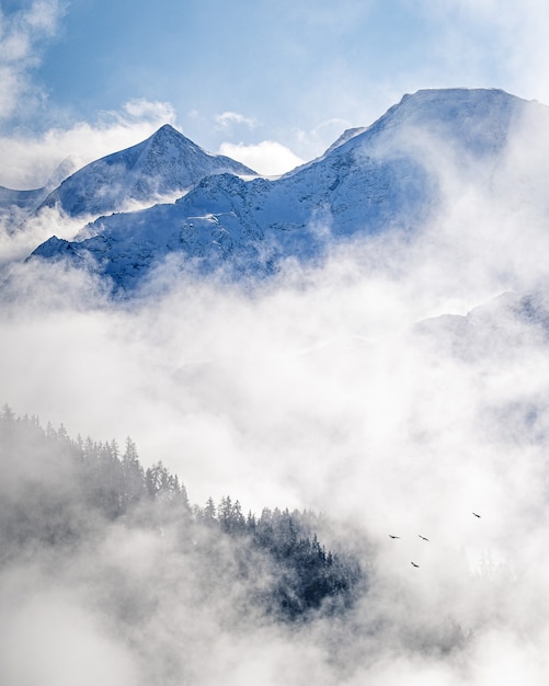 Vertical image of a scenic foggy landscape on alpine mountains