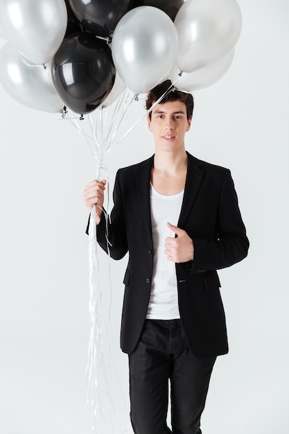 Vertical image of Smiling man holding air balloons