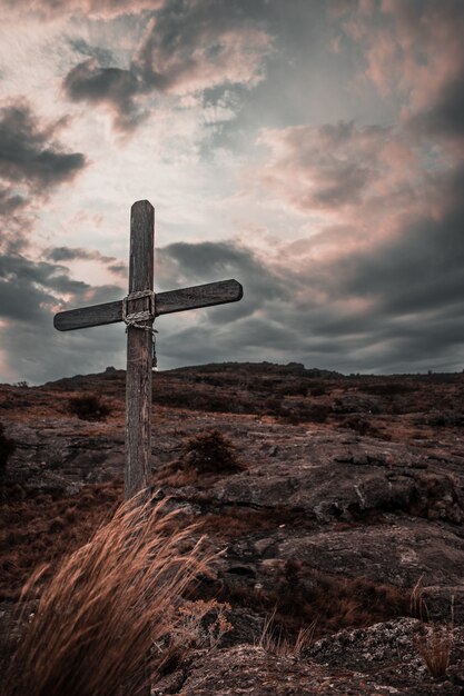 Vertical image of a wooden cross on the rocky mountains of Mallin in Cordoba, Argentina