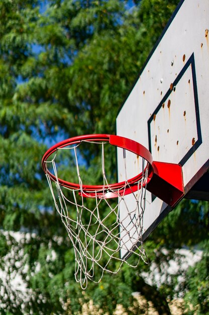 Vertical low angle shot of a basketball hoop with a blurred