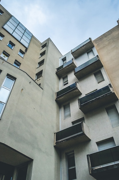 Vertical low angle shot of a brown abstract architectural building with balconies and windows