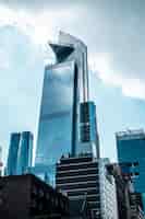 Foto gratuita colpo verticale di angolo basso delle costruzioni di vetro moderne di affari che toccano il cielo