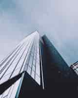Бесплатное фото Вертикальный низкий угол выстрела высотного здания в стеклянном фасаде