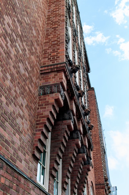 Free photo vertical low angle shot of a red building under the beautiful cloudy sky