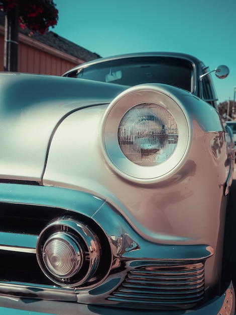 Vertical low angle shot of a silver vintage car at the street