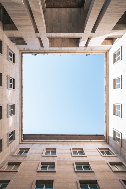 Foto gratuita inquadratura dal basso verticale di un quadrato con il cielo formato da edifici
