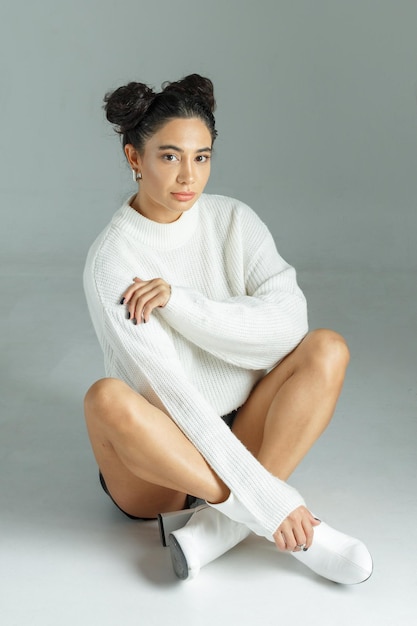 Vertical photo of beautiful girl sitting on ground and looking at the camera high quality photo