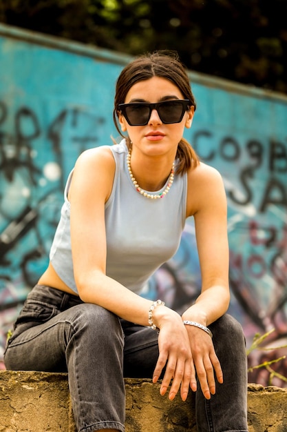 Free photo vertical photo of cute lady sitting at the park and looking at the camera