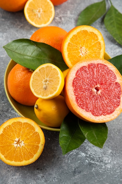 黄色いボウルに新鮮な柑橘系の果物の垂直写真。