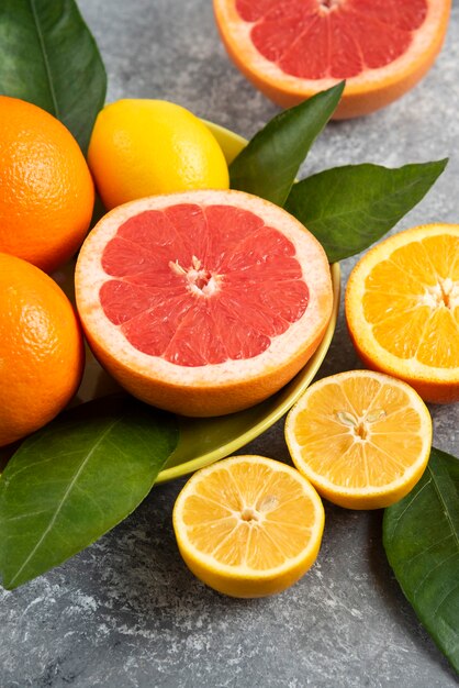 신선한 유기농 과일의 세로 사진입니다. 레몬과 오렌지를 곁들인 자몽.
