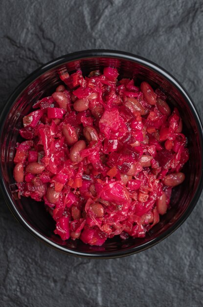 Vertical photo of homemade Vinaigrette with Beans in black bowl .