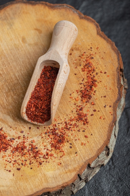 Vertical photo of red hot chili pepper on wooden board.