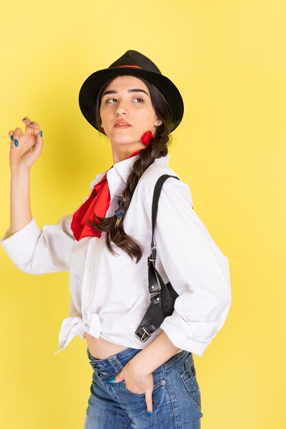 Vertical photo of serious cowgirl on yellow background High quality photo