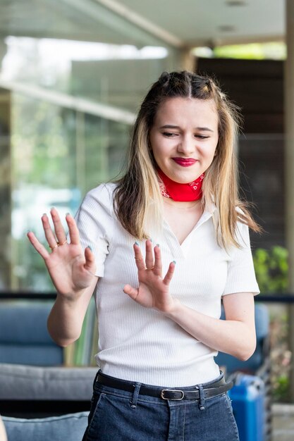 Vertical photo of young beautiful lady holding her hands open and stand on