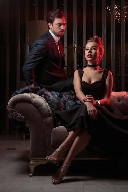 Vertical photo of young couple in elegant dark room