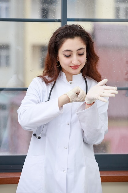 手袋をはめた若い女性の医療従事者の垂直写真高品質の写真