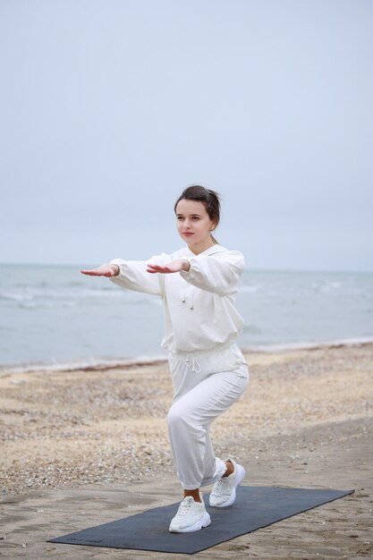 Vertical photo of young girl doing her exercises on the mat High quality photo