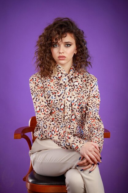 Vertical photo of young lady sitting on purple background High quality photo