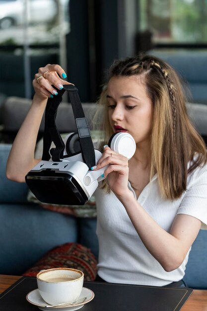 Вертикальное фото юной леди в VR-наборе в ресторане