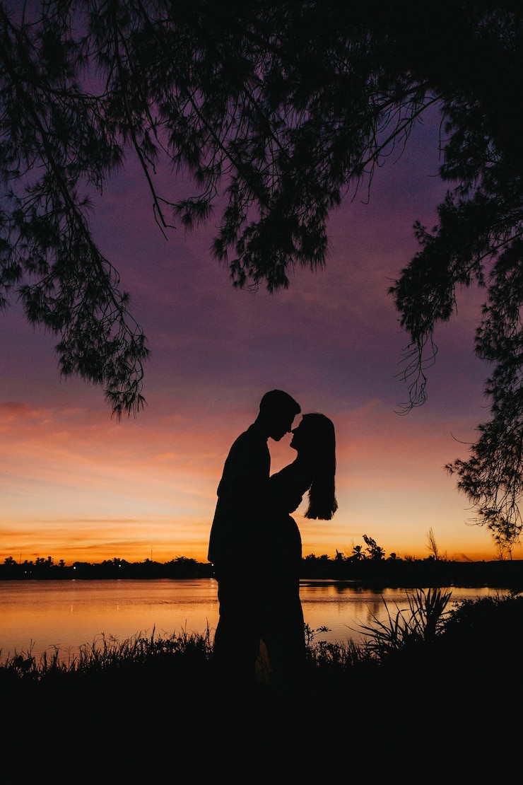 Free Photo vertical picture of beautiful silhouettes of lovers against a mesmerizing sky