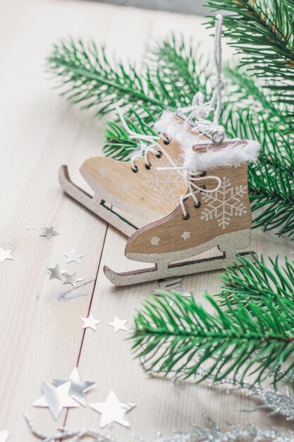 Vertical picture of little wooden toy skates surrounded by decorations under the lights