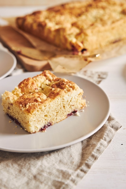 Vertical picture of a piece of delicious Jerry Crumble Sheet cake on a white wood table