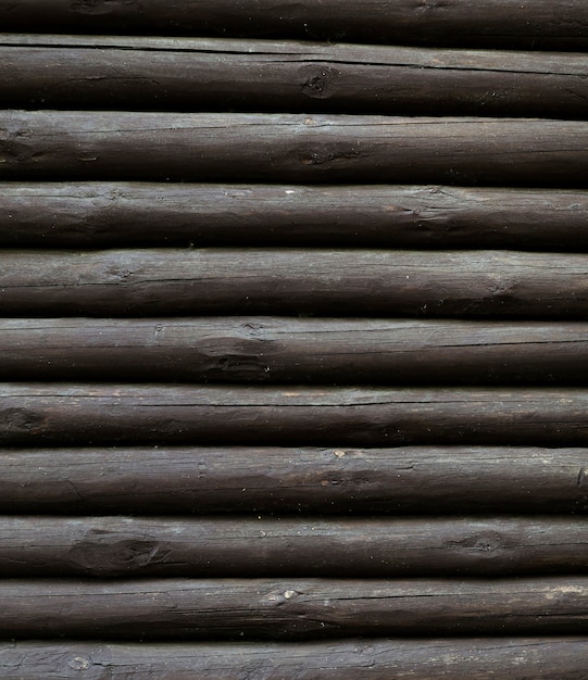 Vertical pile of wooden tree trunks