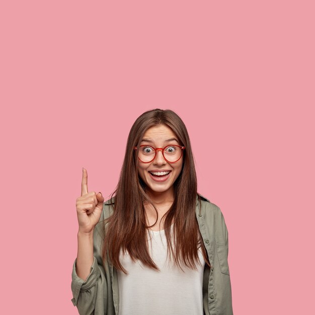 Vertical portrait of happy student posing against the pink wall