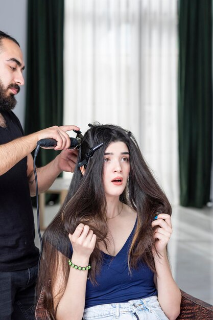 Vertical portrait of young Barber making his client39s hair High quality photo