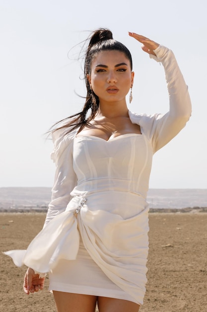 Vertical portrait of a young beautiful in desert on a sunny day looking at the camera High quality photo