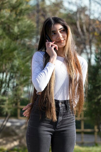 Vertical portrait of young beautiful girl talking on the phone High quality photo