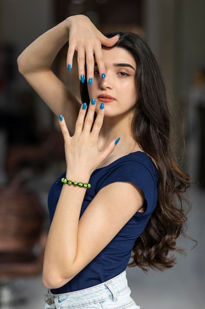 Vertical portrait of young girl holding her hands to her face and looking at the camera High quality photo