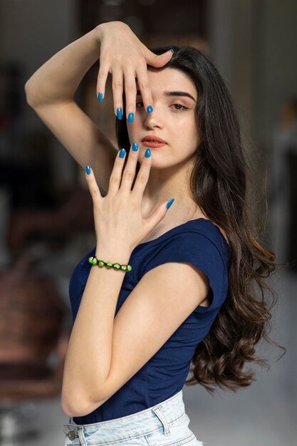 Vertical portrait of young girl holding her hands to her face and looking at the camera High quality photo