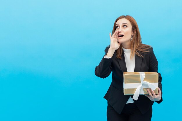 Vertical portrait of young lady holding present box and shouted someone