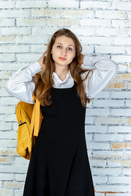 Free photo vertical portrait of young schoolgirl looking at the camera