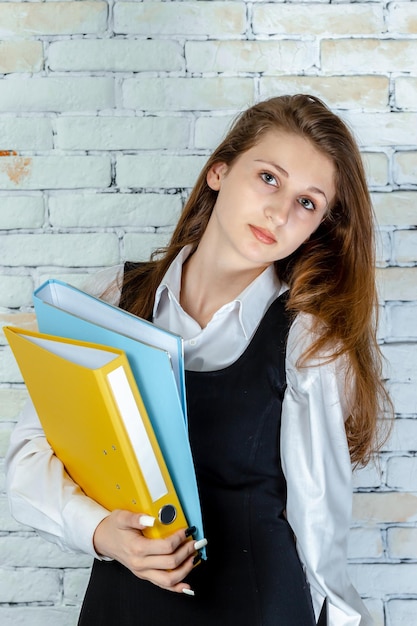 Vertical portrait of young student holding her notebooks High quality photo