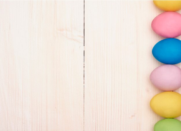 Vertical row of multi colored eggs on the plank