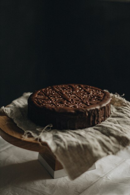 Vertical selective closeup shot of chocolate cake on a fabric on a round table
