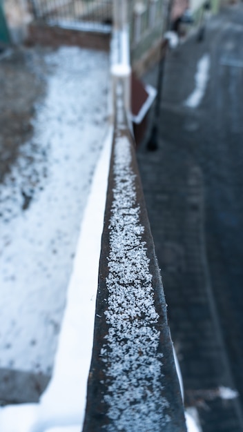 Foto gratuita messa a fuoco selettiva verticale di neve in una ringhiera a sibiu, romania