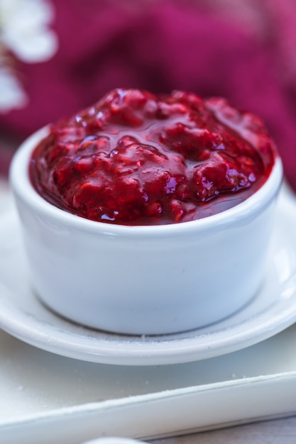 Vertical selective focus shot of a tasty looking raspberry jam