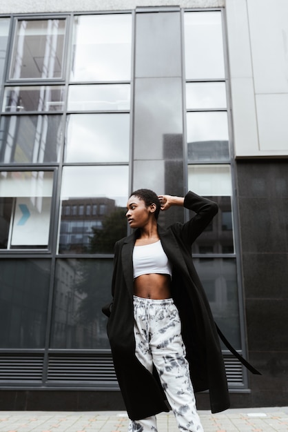 Free photo vertical shot of an african-american woman wearing a coat an posing in the street