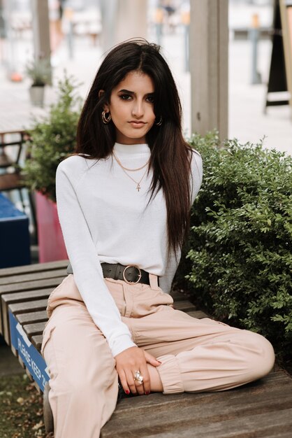 Vertical shot of an Asian young woman posing in the street