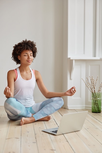 Free photo vertical shot of attractive african american woman keeps legs crossed