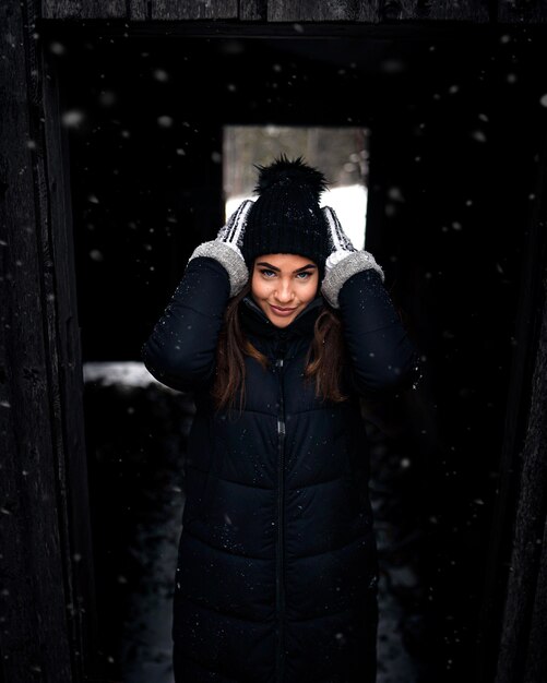 Vertical shot of an attractive female fixing her knit cap