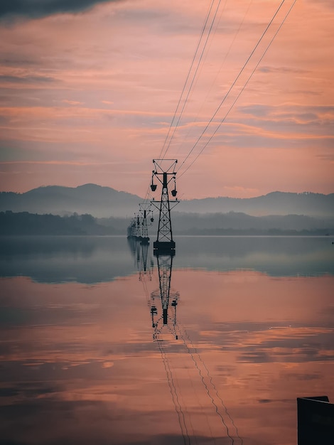 Vertical shot of an awesome view for the electrical towers in the sea and their reflection in water